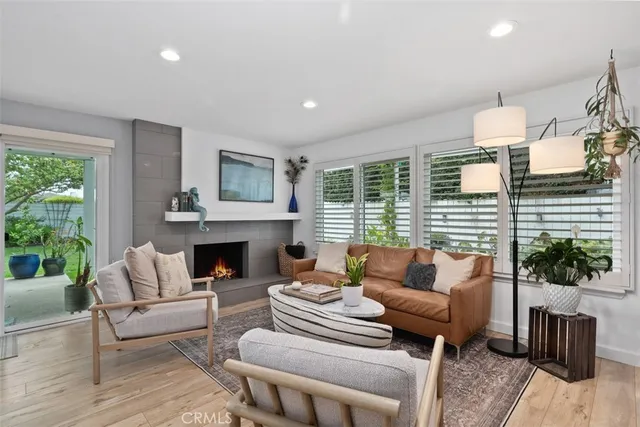 a living room with furniture fireplace and potted plants