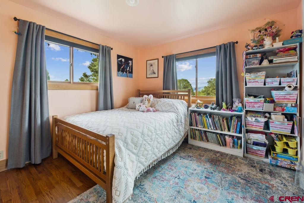 948 Sage Road Montrose, CO 81403 - Photo 16 of 45 a bedroom with a bed a book shelf and a window