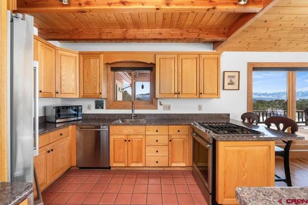 a kitchen with stainless steel appliances granite countertop a stove a sink and a microwave
