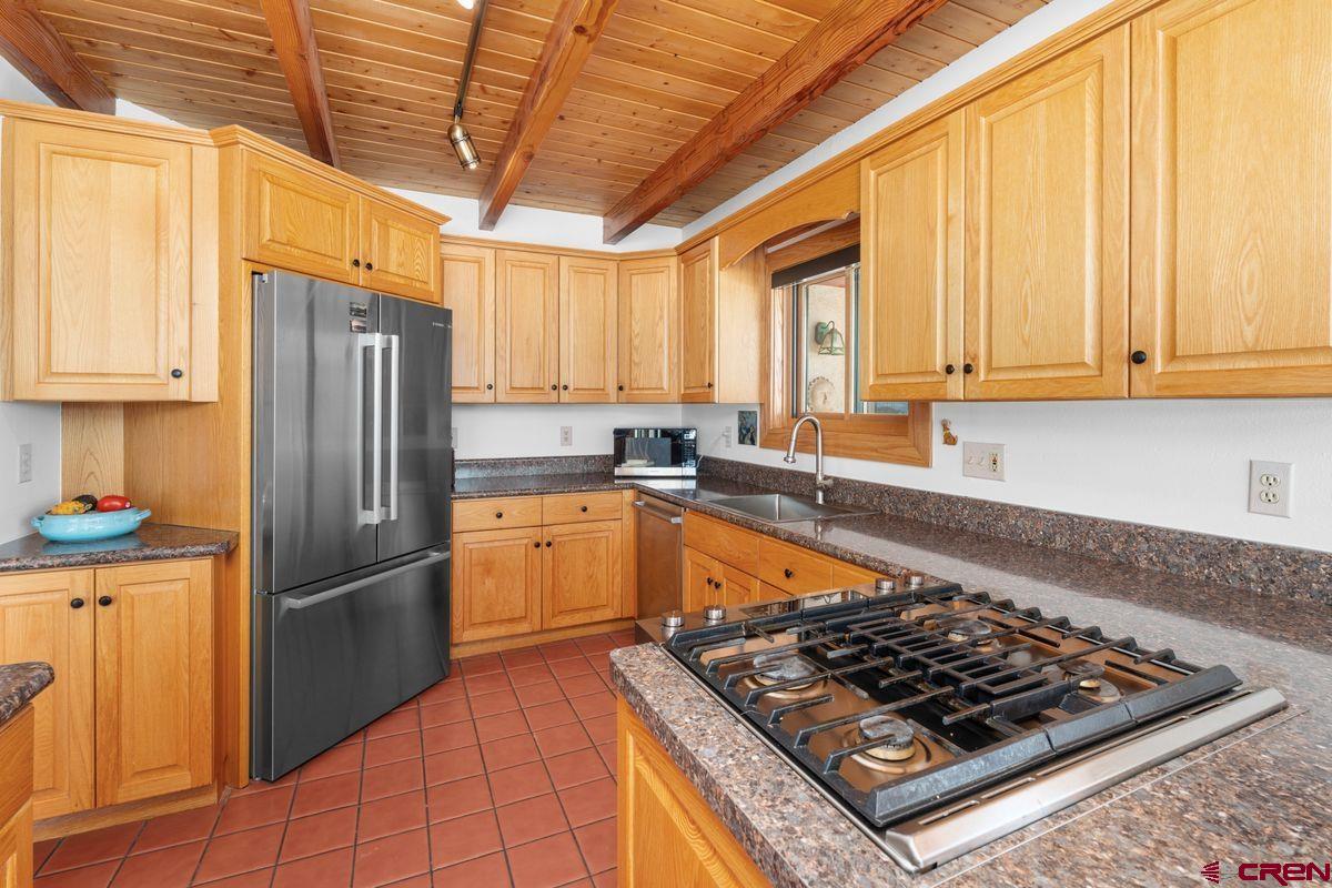 948 Sage Road Montrose, CO 81403 - Photo 7 of 45 a kitchen with stainless steel appliances granite countertop a sink stove refrigerator and cabinets