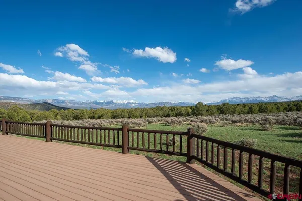 a view of balcony with wooden floor & fence