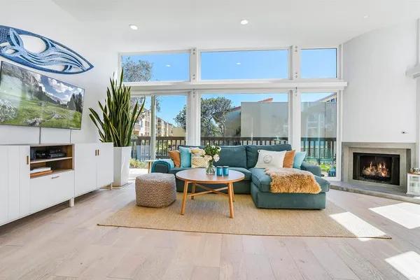 a living room with furniture a fireplace and a floor to ceiling window