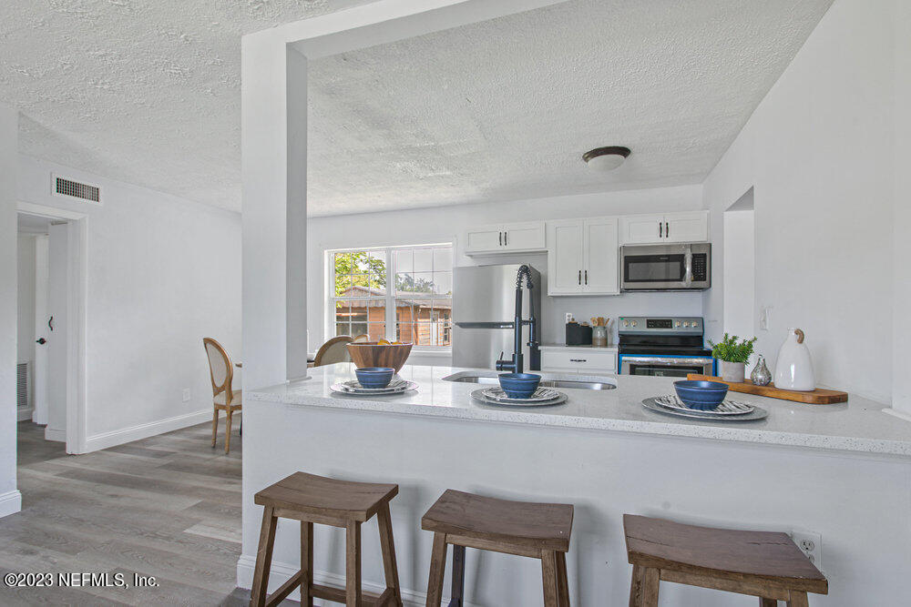 7036 Camelot Road Jacksonville, FL 32211 - Photo 7 of 27 a dining room with stainless steel appliances granite countertop a dining table and chairs