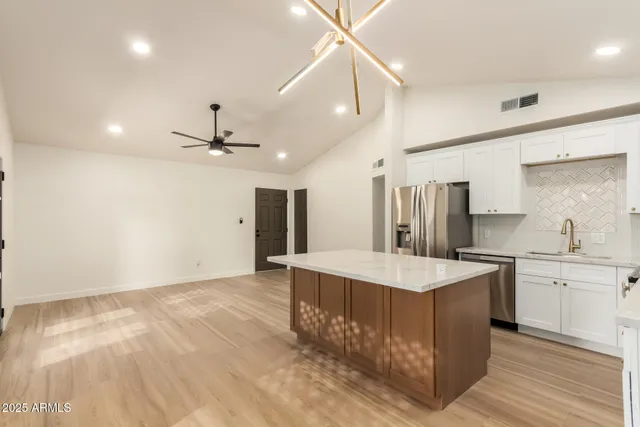 a large kitchen with kitchen island a sink stainless steel appliances and cabinets