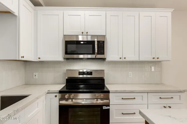 a kitchen with white cabinets stainless steel appliances and sink