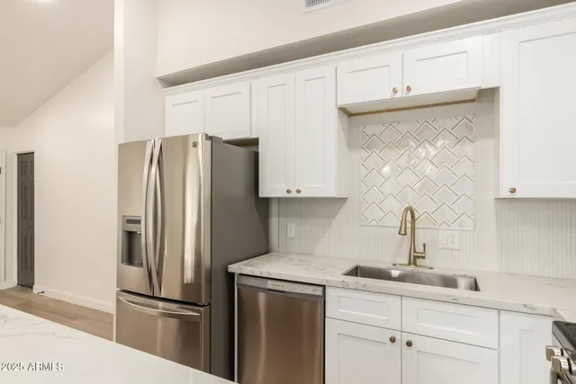 a kitchen with stainless steel appliances a refrigerator and a sink