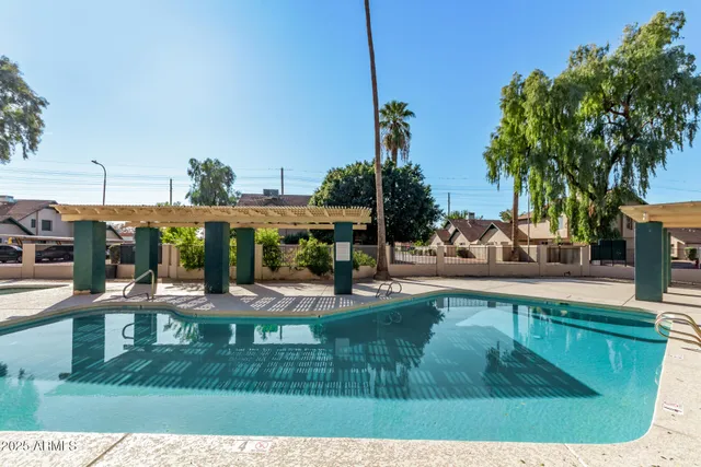 a view of a house with potted plants and a large tree