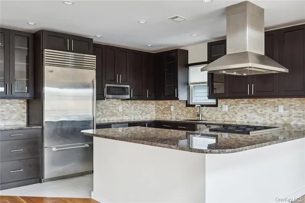 a kitchen with stainless steel appliances granite countertop a sink and a refrigerator
