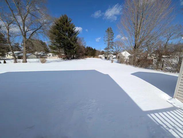 a front view of a house with a yard covered in snow