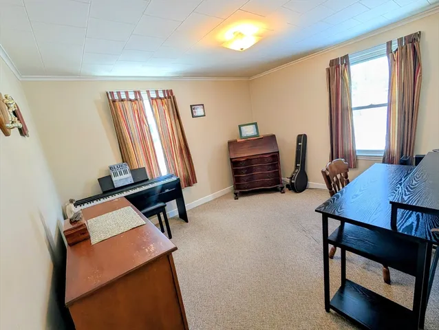 a bedroom with a bed and a flat tv screen on dresser