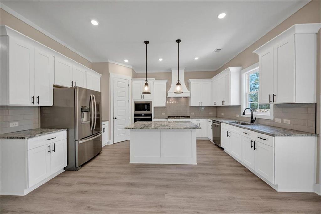 960 Oxford Road Ball Ground, GA 30107 - Photo 14 of 54 a large kitchen with stainless steel appliances kitchen island a sink a stove a refrigerator and white cabinets