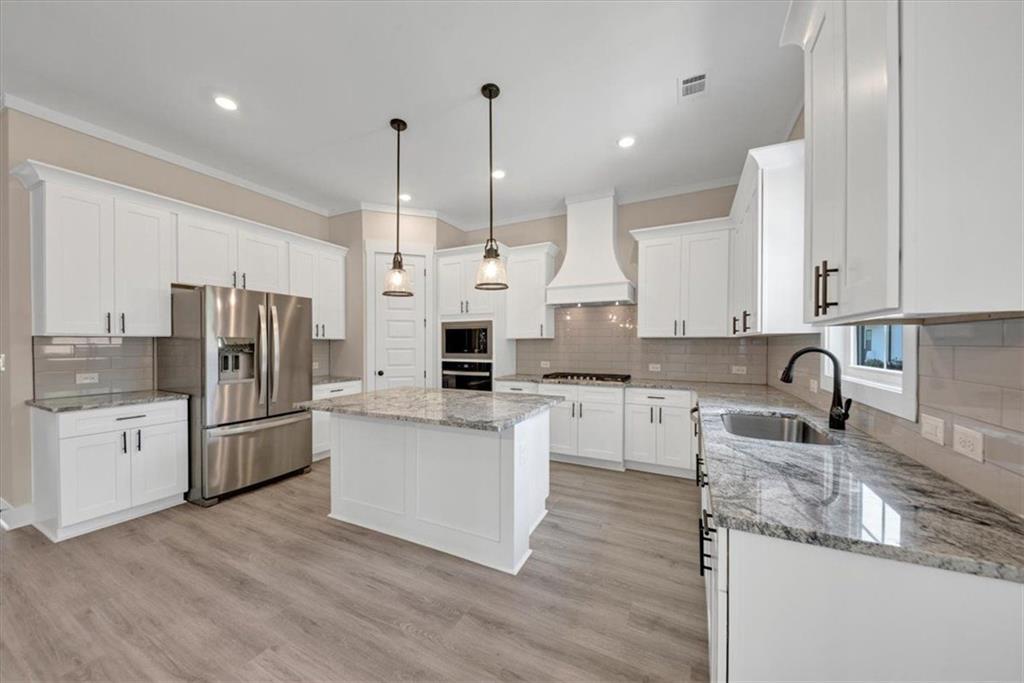 960 Oxford Road Ball Ground, GA 30107 - Photo 15 of 54 a kitchen with stainless steel appliances granite countertop a refrigerator a sink dishwasher a stove and white cabinets with wooden floor
