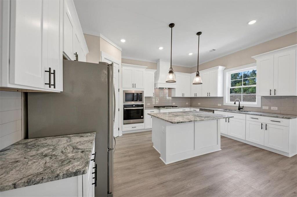 960 Oxford Road Ball Ground, GA 30107 - Photo 16 of 54 a kitchen with stainless steel appliances granite countertop a stove a sink a refrigerator and a oven with wooden floor