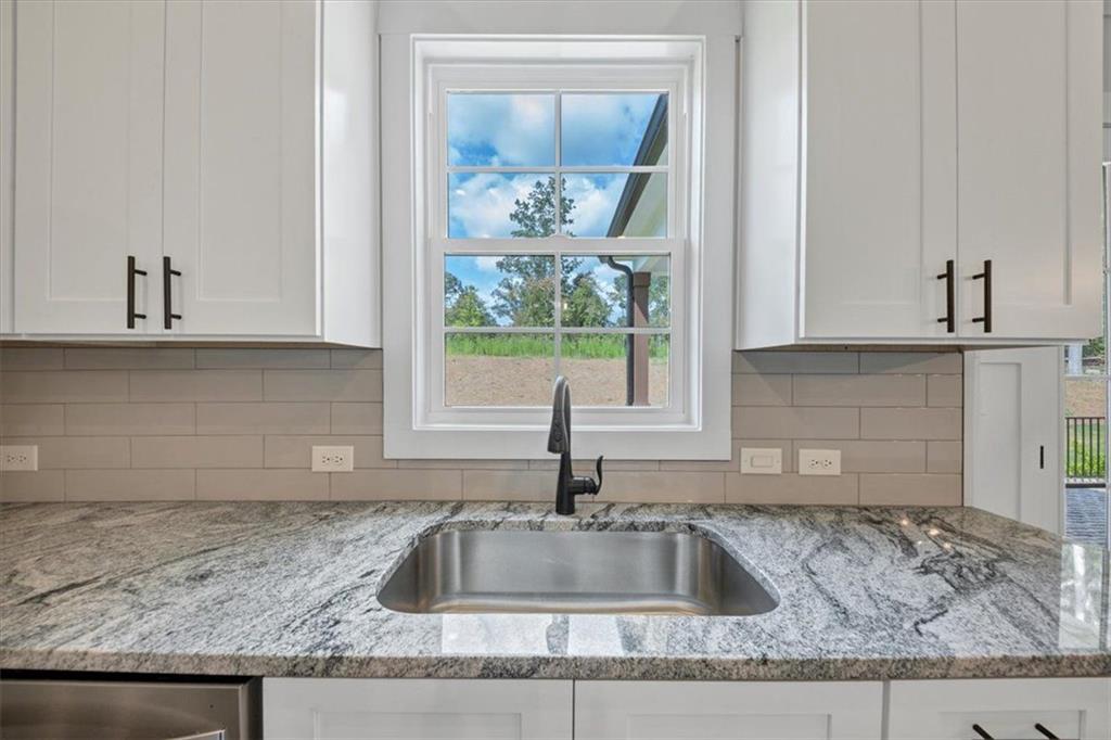 960 Oxford Road Ball Ground, GA 30107 - Photo 19 of 54 a kitchen with granite countertop a sink and a window