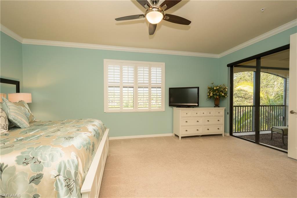 9511 Napoli Lane, Unit 202 Naples, FL 34113 - Photo 11 of 24 a bedroom with a bed and a flat screen tv