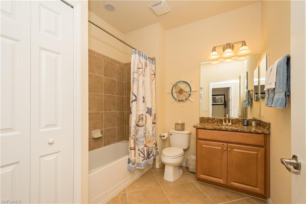 9511 Napoli Lane, Unit 202 Naples, FL 34113 - Photo 15 of 24 a bathroom with a granite countertop toilet a sink and a bathtub