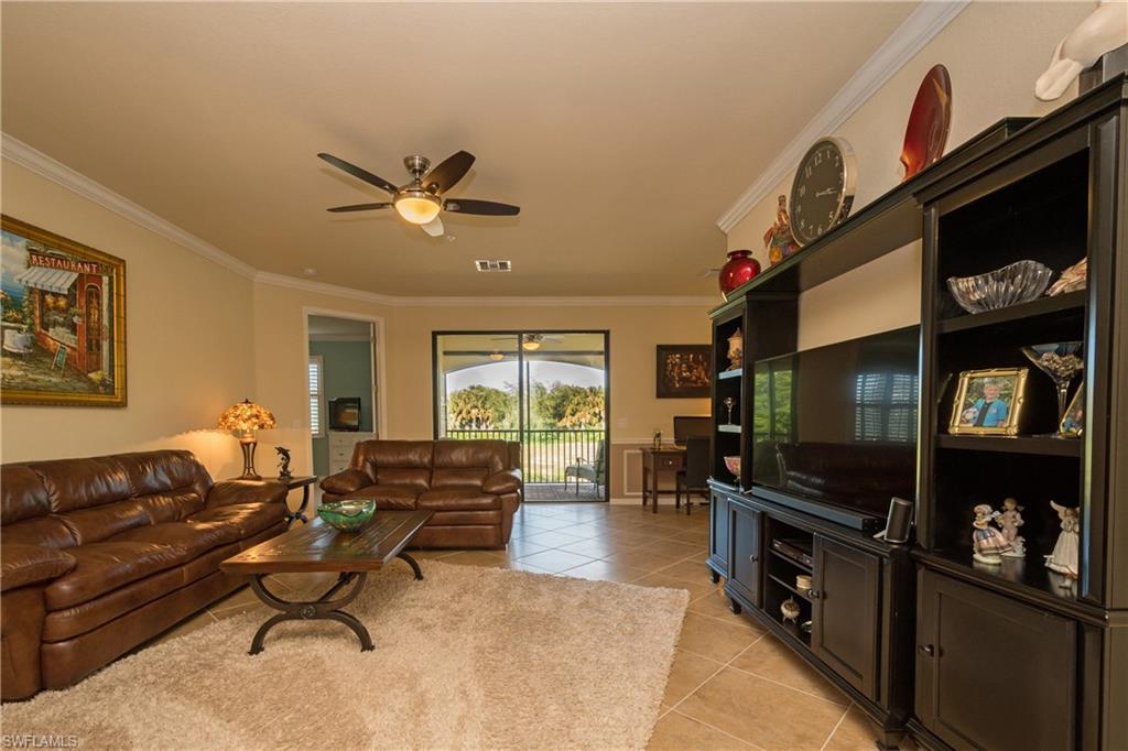9511 Napoli Lane, Unit 202 Naples, FL 34113 - Photo 2 of 24 a living room with furniture a window and a flat screen tv
