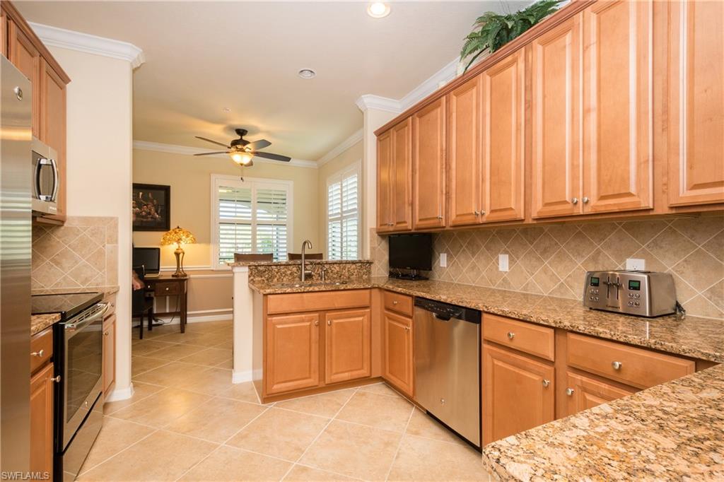 9511 Napoli Lane, Unit 202 Naples, FL 34113 - Photo 6 of 24 a kitchen with stainless steel appliances granite countertop a stove a sink dishwasher and a refrigerator