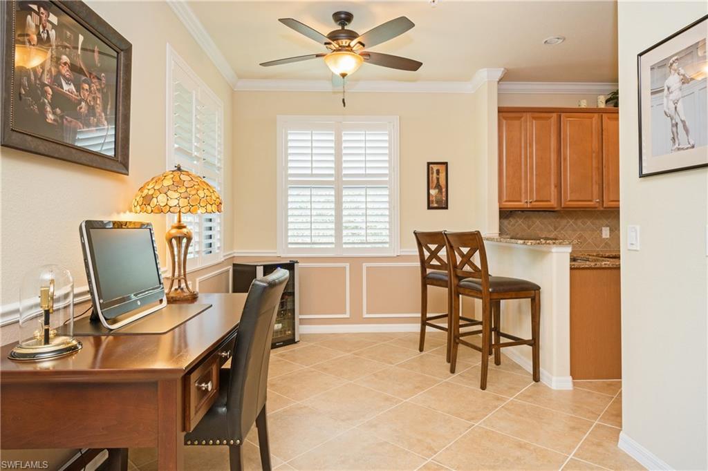 9511 Napoli Lane, Unit 202 Naples, FL 34113 - Photo 9 of 24 a workspace with chandelier a desk and chair