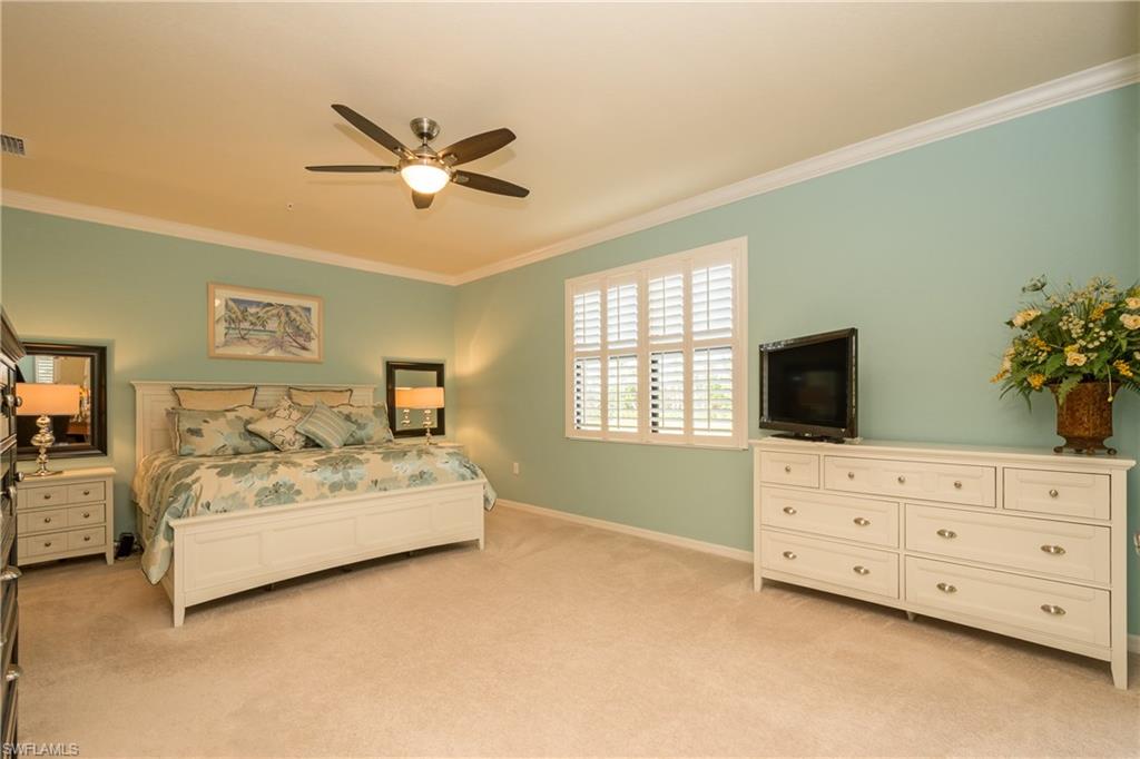 9511 Napoli Lane, Unit 202 Naples, FL 34113 - Photo 10 of 24 a bedroom with a bed and a flat screen tv