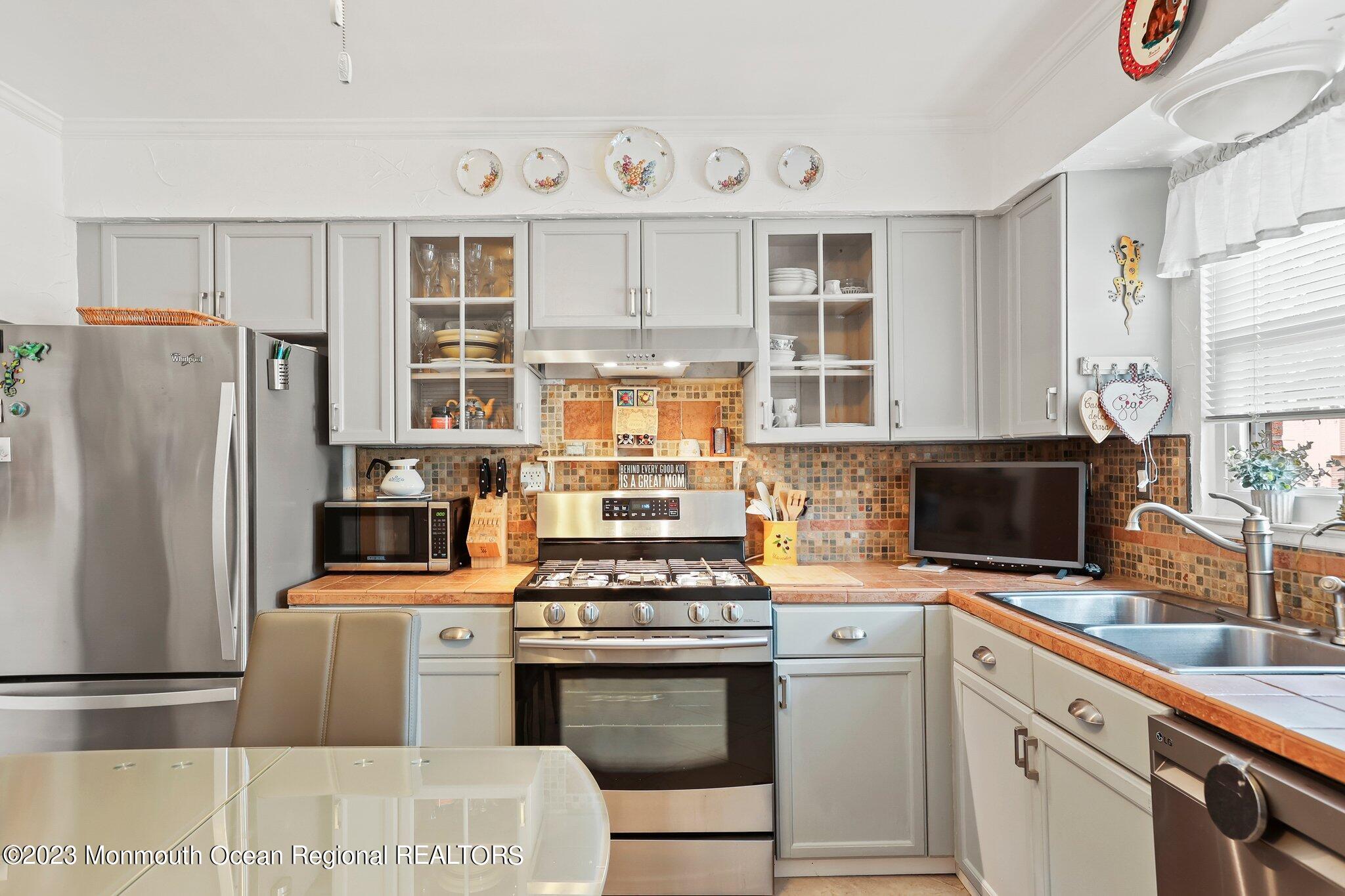 301 Spring Street, Unit 1 Red Bank, NJ 07701 - Photo 12 of 23 a kitchen with stainless steel appliances a stove a sink and a refrigerator