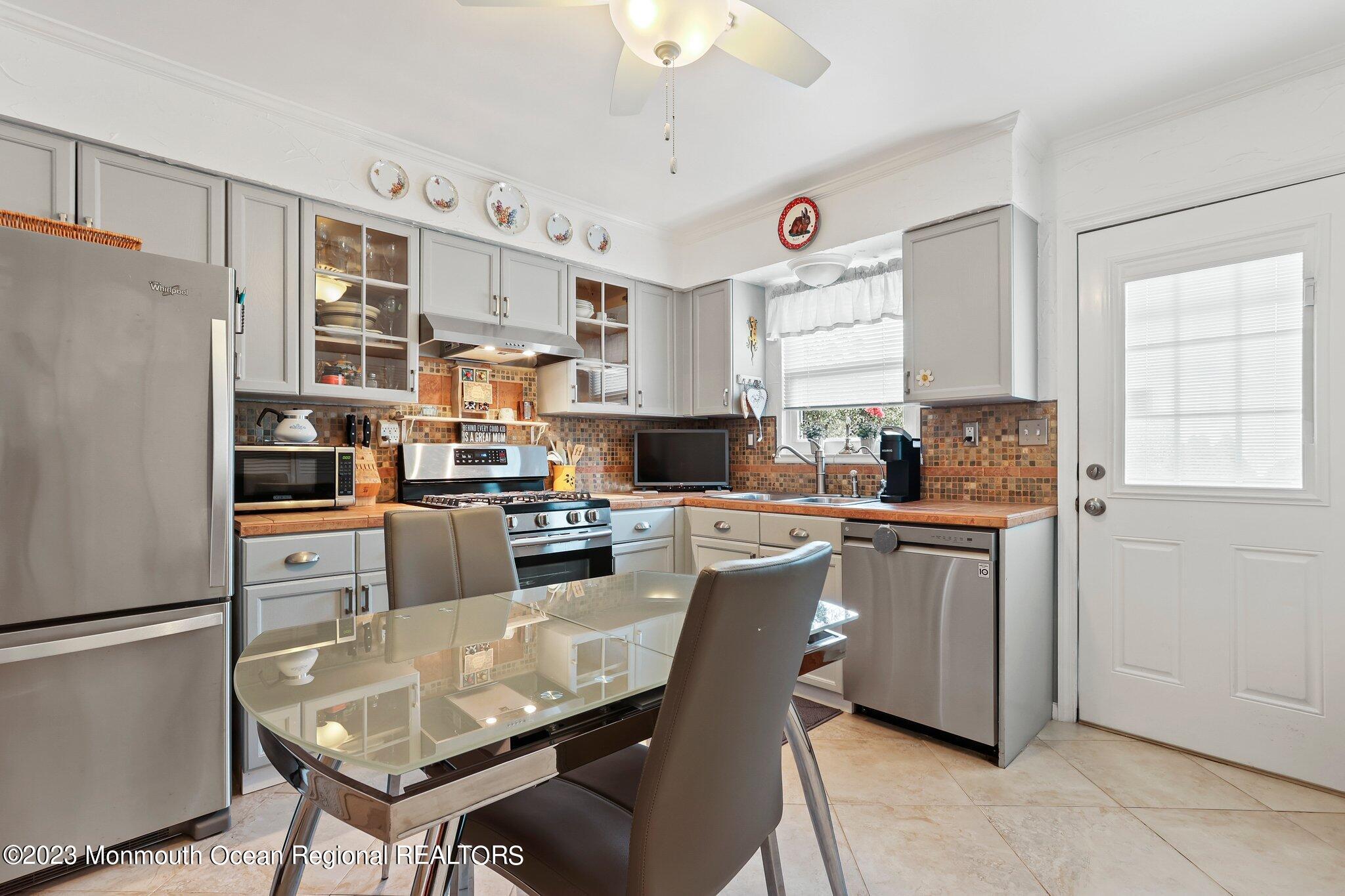 301 Spring Street, Unit 1 Red Bank, NJ 07701 - Photo 10 of 23 a kitchen with stainless steel appliances granite countertop a refrigerator sink stove microwave and cabinets