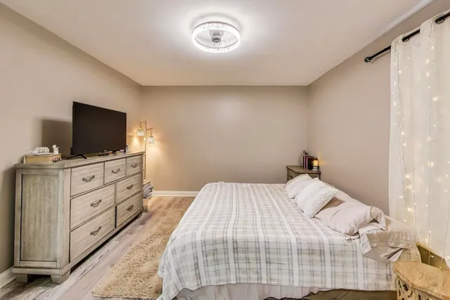 a bedroom with a bed and a flat tv screen on a dresser