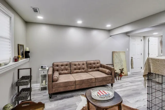 a living room with furniture and a wooden floor