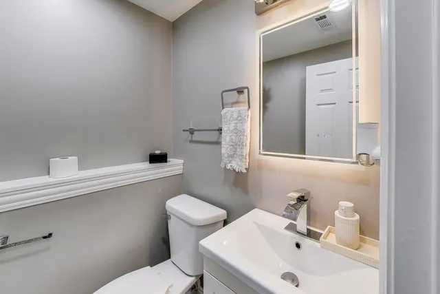 a bathroom with a sink mirror and toilet