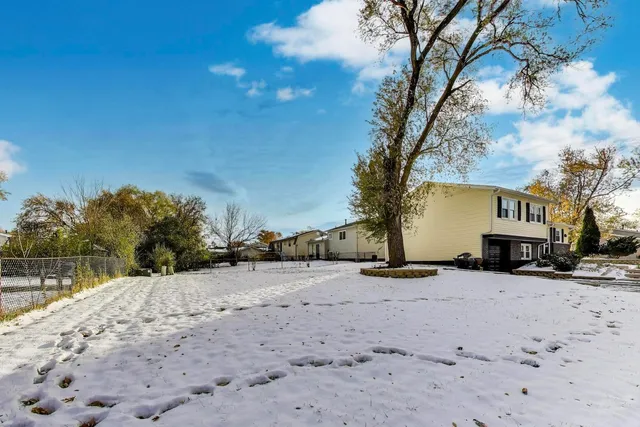 a view of a yard covered with snow in front of house