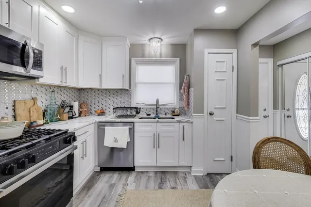 a kitchen with cabinets appliances and a wooden floor
