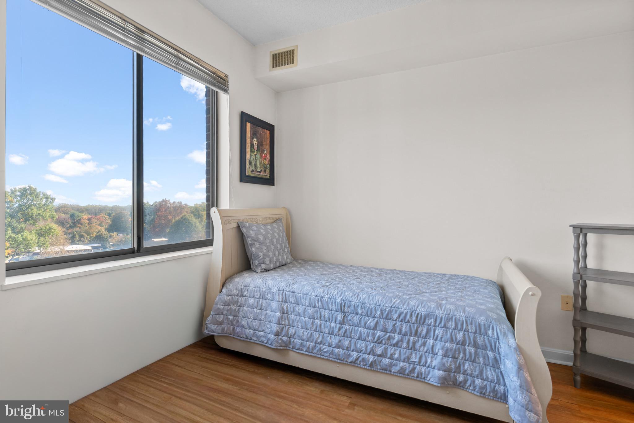 3005 South Leisure World Boulevard, Unit 702 Silver Spring, MD 20906 - Photo 20 of 43 a bedroom with a bed and wooden floor