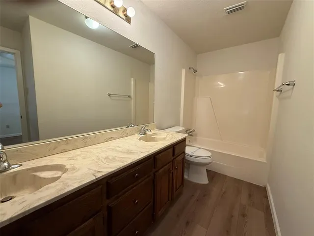 a bathroom with a granite countertop sink toilet a large mirror and shower