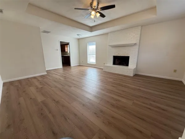 a view of an empty room with a fireplace and a window