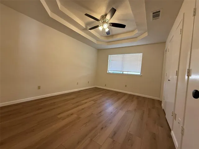 an empty room with wooden floor and windows