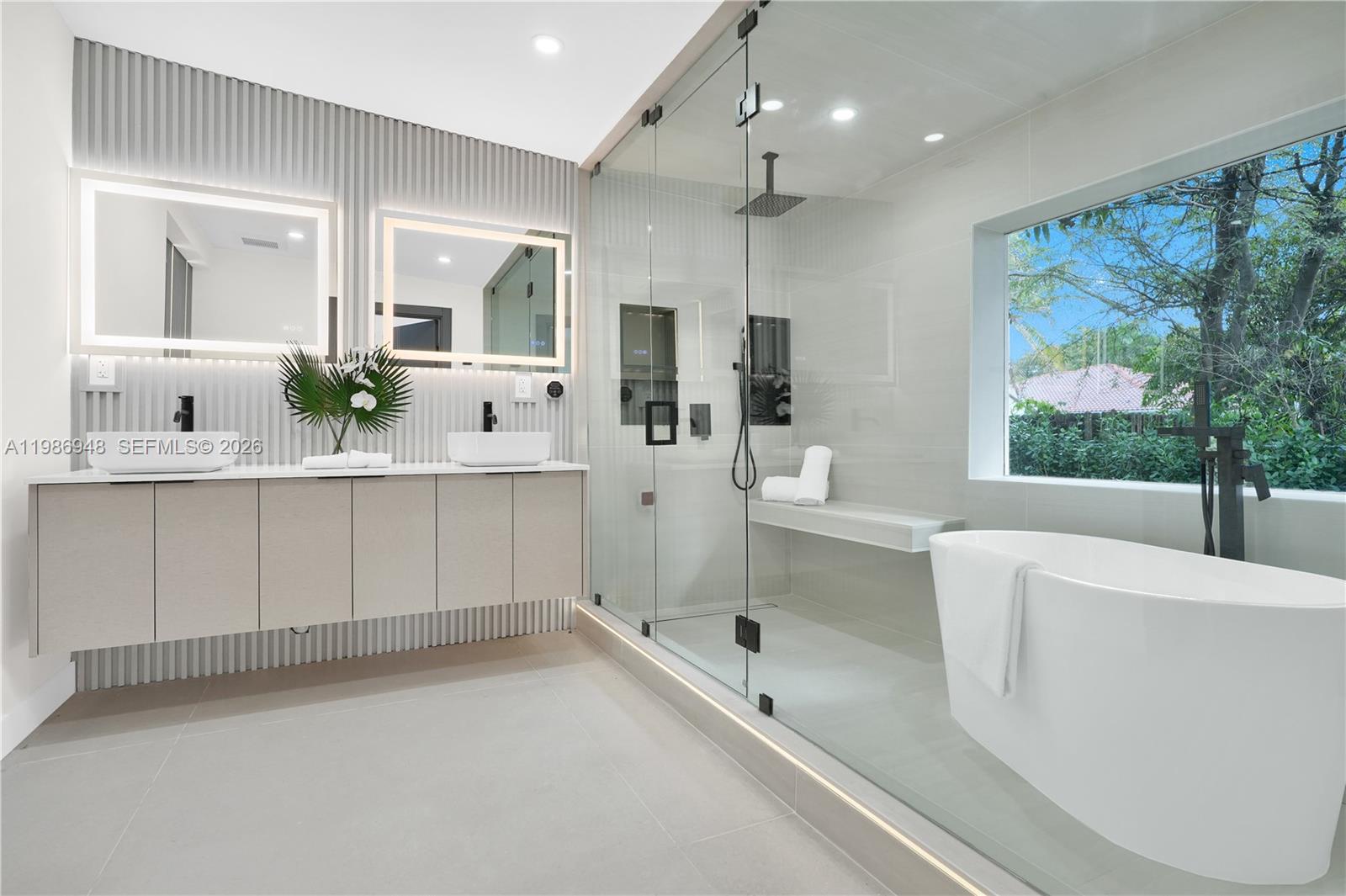 8220 Southwest 133rd Street Pinecrest, FL 33156 - Photo 17 of 34 a large white bathroom with a large tub a sink and window