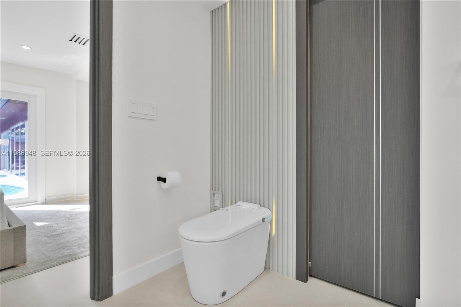 8220 Southwest 133rd Street Pinecrest, FL 33156 - Photo 19 of 34 a white toilet sitting next to a bathroom sink