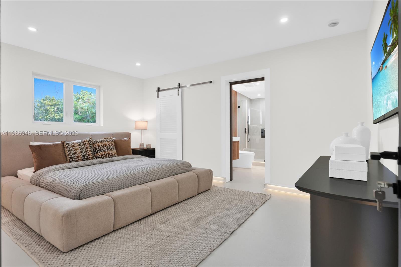 8220 Southwest 133rd Street Pinecrest, FL 33156 - Photo 20 of 34 a spacious bedroom with a bed and a flat screen television