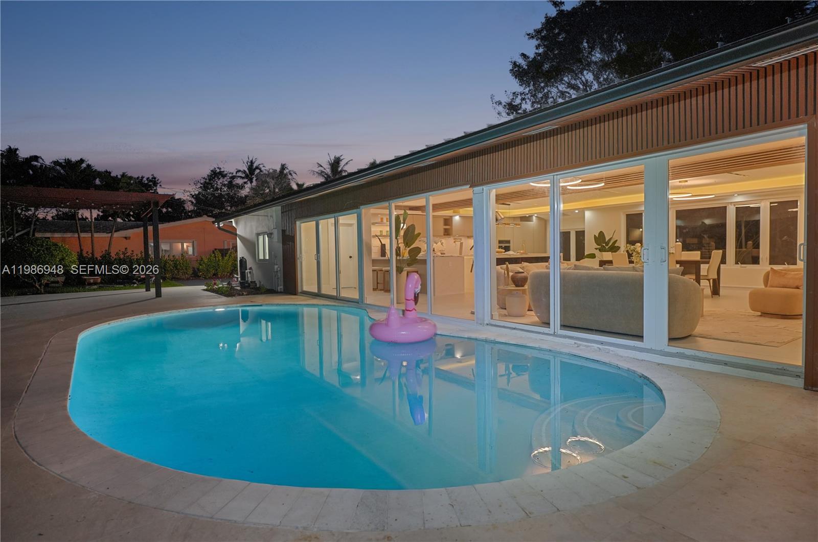 8220 Southwest 133rd Street Pinecrest, FL 33156 - Photo 26 of 34 a view of a swimming pool with an outdoor seating