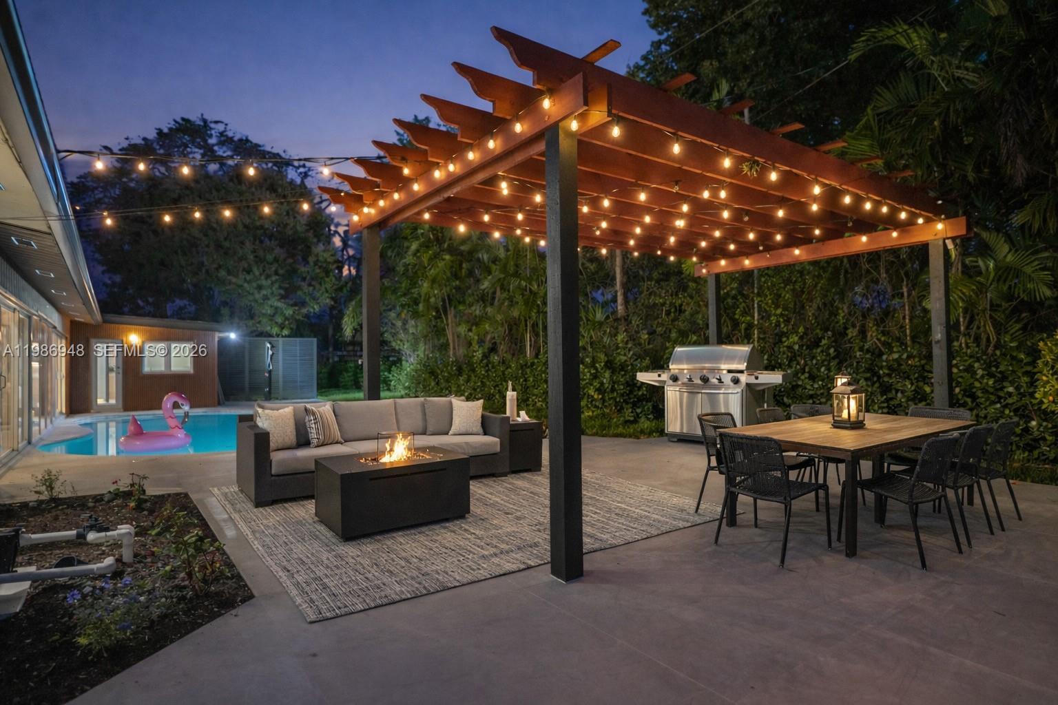 8220 Southwest 133rd Street Pinecrest, FL 33156 - Photo 27 of 34 a backyard view of a house with fire pit and outdoor seating