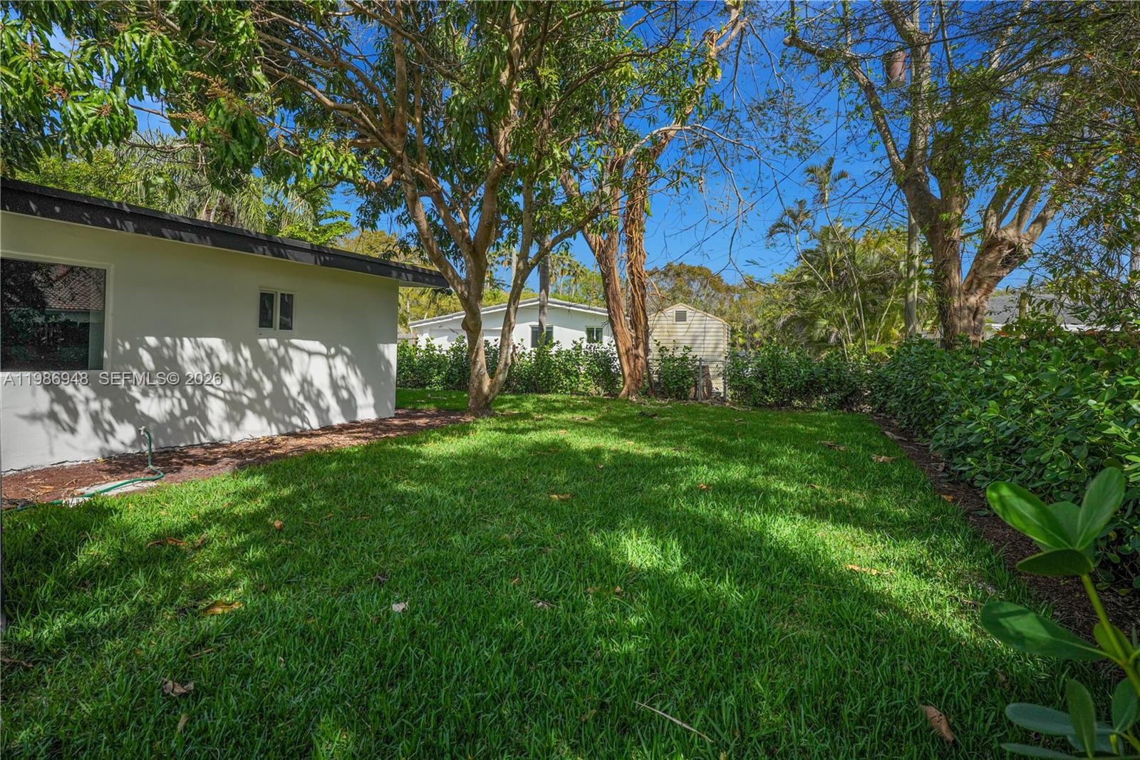 8220 Southwest 133rd Street Pinecrest, FL 33156 - Photo 30 of 34 a view of a backyard with table and chairs and a large tree