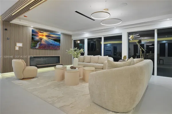 a living room with furniture a fireplace and a floor to ceiling window