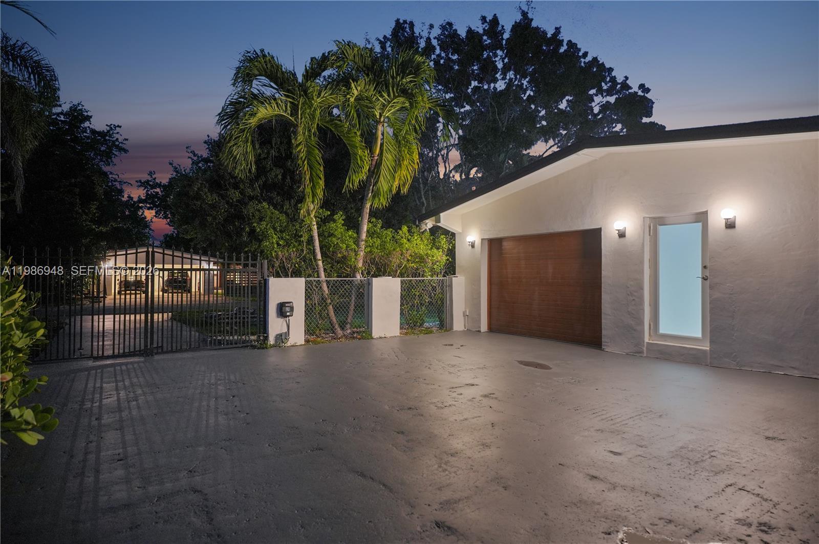 8220 Southwest 133rd Street Pinecrest, FL 33156 - Photo 7 of 34 a view of a house with a yard and potted plants