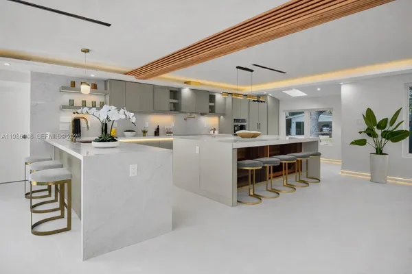 a room with stainless steel appliances kitchen island granite countertop furniture and a floor to ceiling window