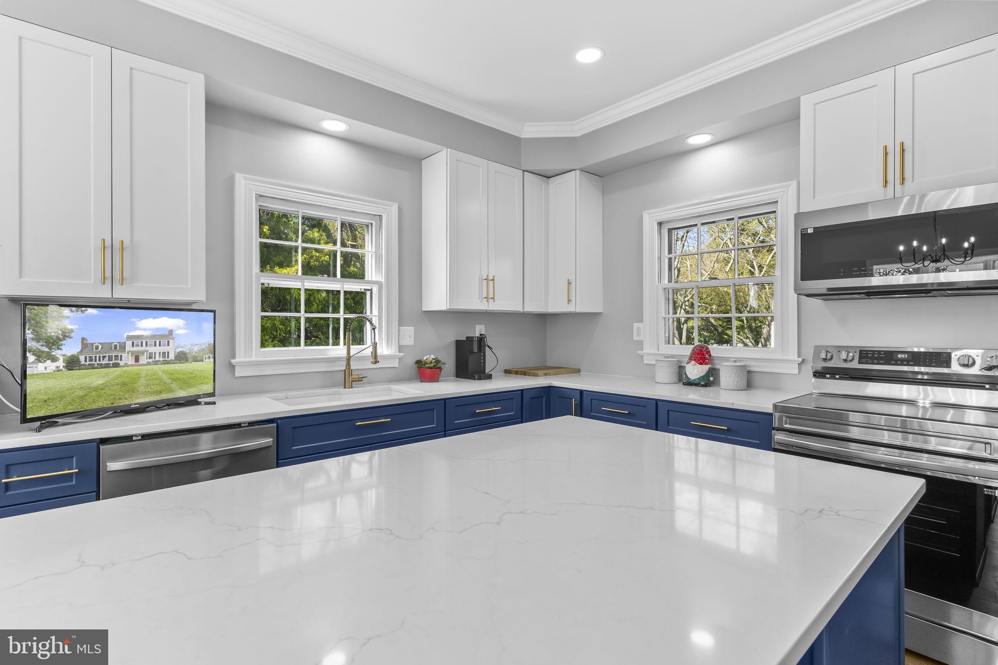 525 Small Reward Road Huntingtown, MD 20639 - Photo 22 of 67 a kitchen with stainless steel appliances a sink a stove a microwave and cabinets