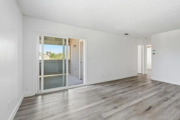 an empty room with wooden floor and door