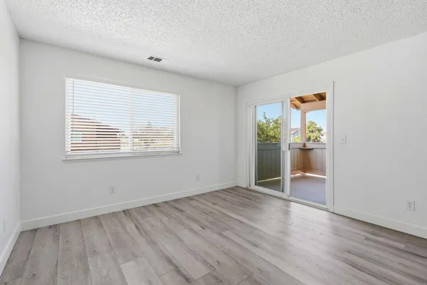 an empty room with wooden floor and a window