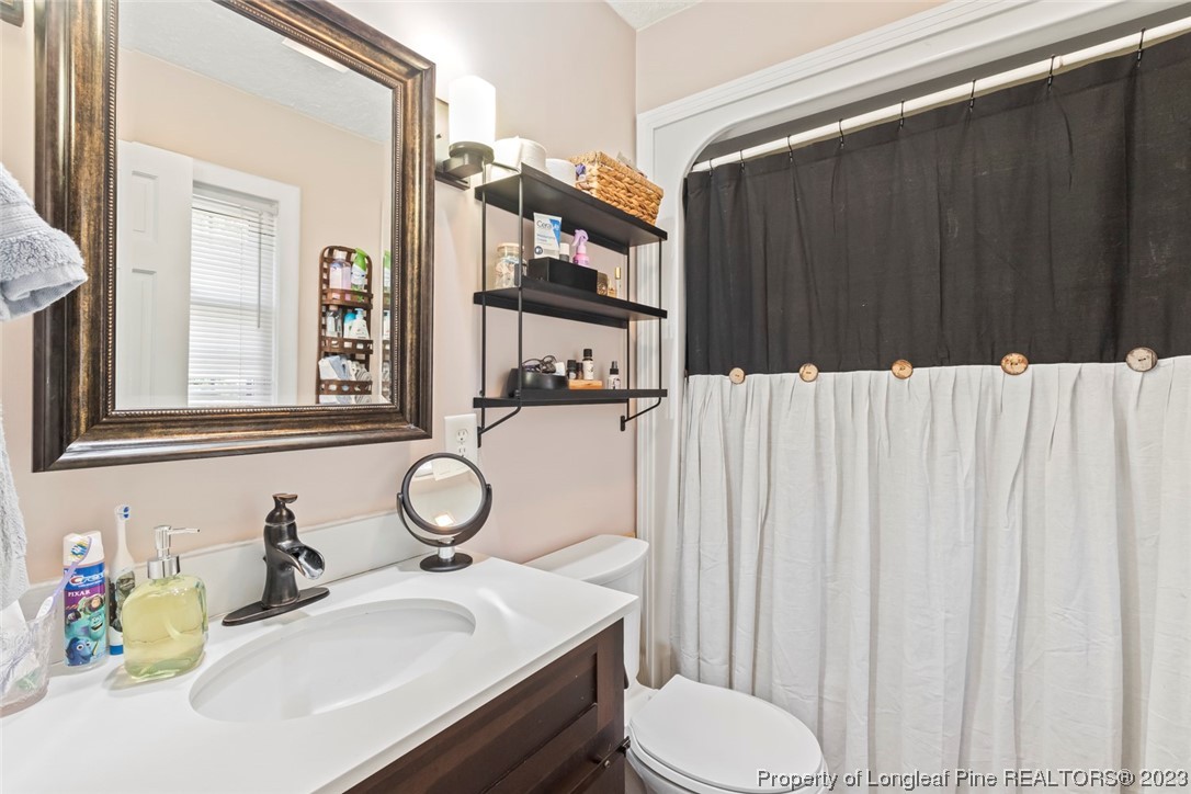 1036 Pendergrass Road Sanford, NC 27330 - Photo 18 of 31 a bathroom with a sink vanity mirror and toilet