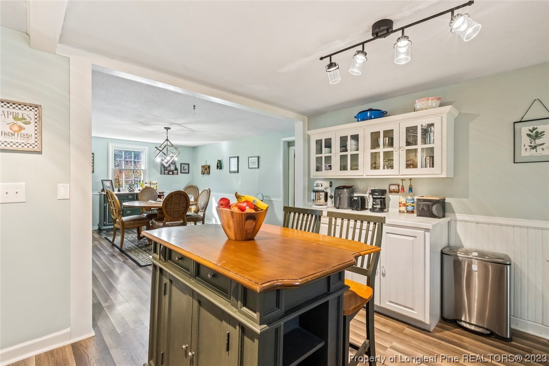 1036 Pendergrass Road Sanford, NC 27330 - Photo 23 of 31 a living room with a table chairs and a refrigerator