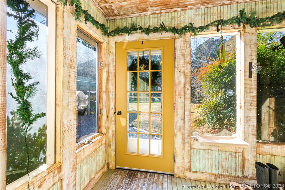 1036 Pendergrass Road Sanford, NC 27330 - Photo 10 of 31 a view of a porch with a floor to ceiling window and potted plants